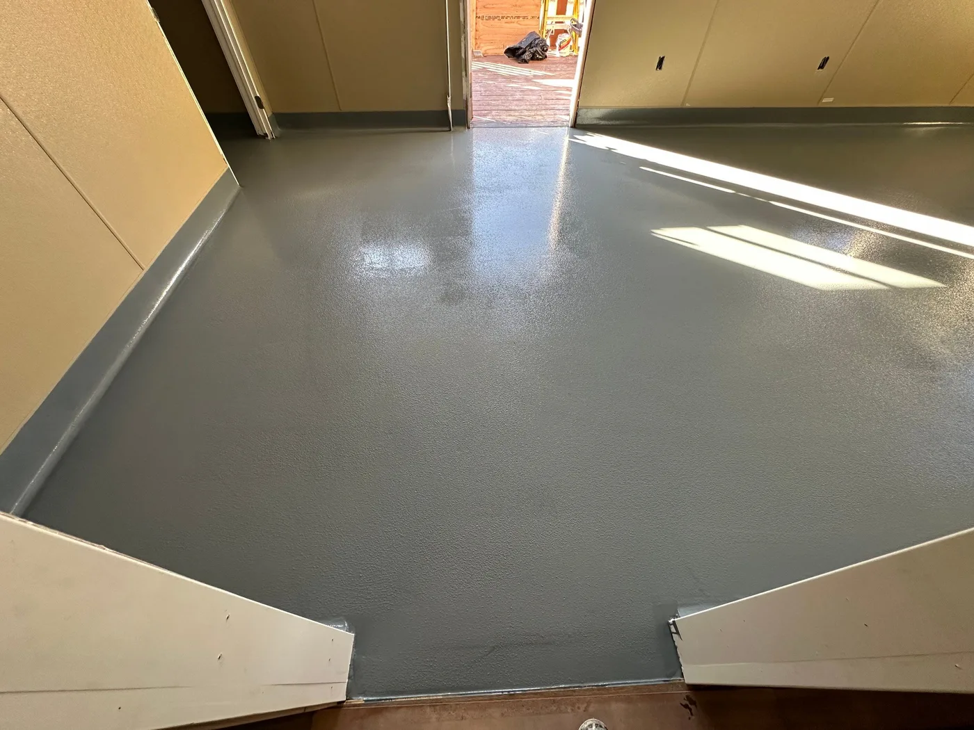 Gray epoxy floor with cove base running up the wall in a commercial facility